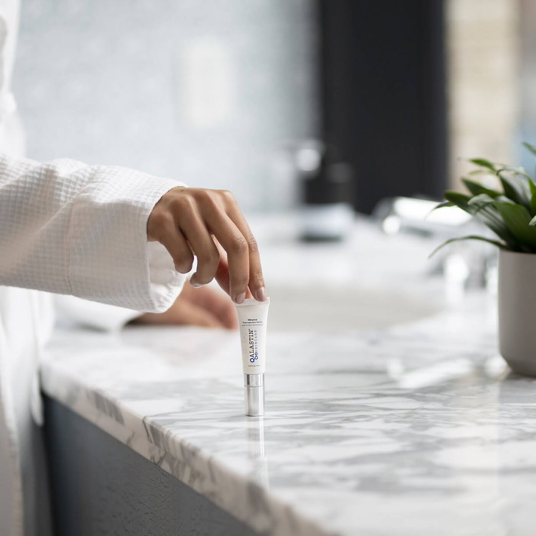Woman Setting Down Bottle of Liquid Post Surgery Serum on Counter